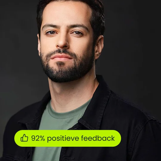 Formele portretfoto van een glimlachende zakenman in een marineblauwe blazer en overhemd tegen een zwarte studioachtergrond.