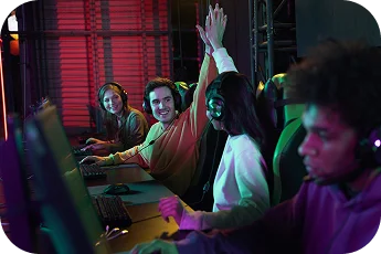 Esports-team viert een overwinning tijdens een LAN-game-evenement en steekt hun handen in de lucht terwijl ze headsets dragen in een met neon verlichte game-arena.