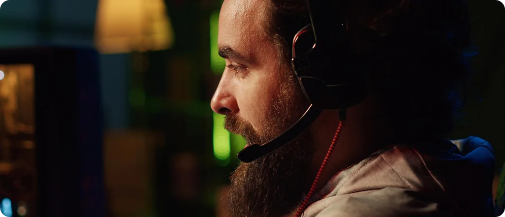 Professionele esports-speler met een gamingheadset op, gefocust op het scherm tijdens een competitieve online wedstrijd in een met neon verlichte kamer.